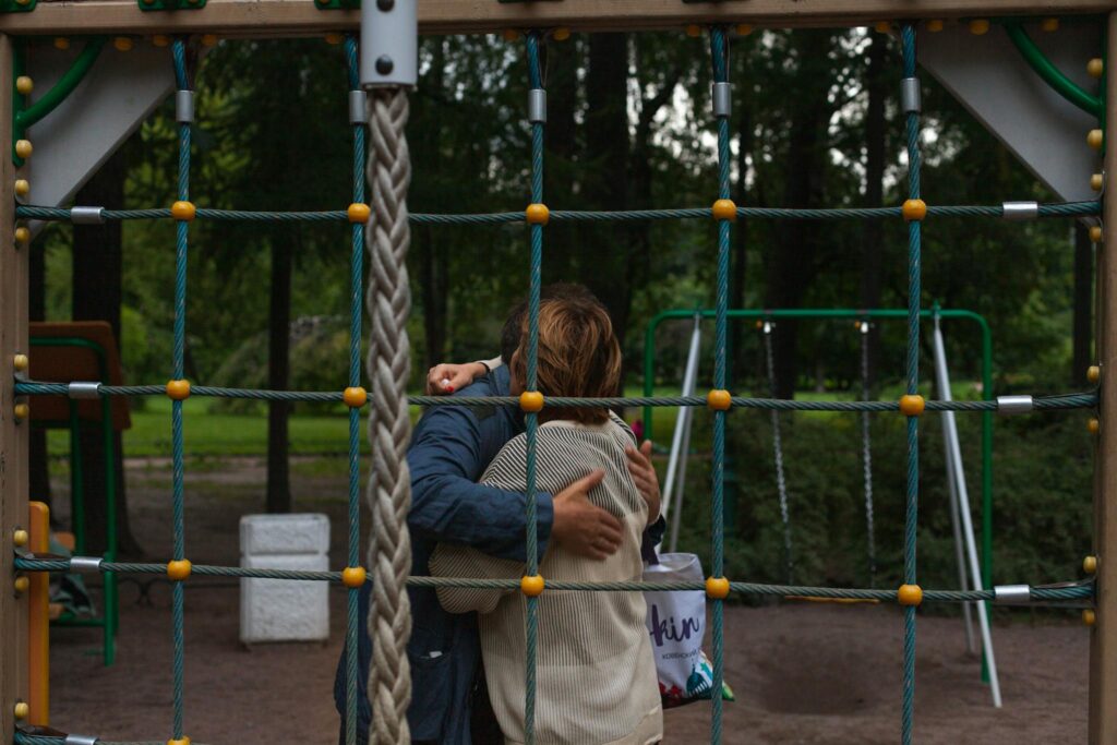A couple shares an embrace on a playground, symbolizing love and connection.
